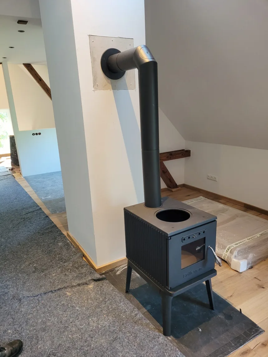 Kaminofen vor einer neuen Wand im ausgebauten Dachgeschoss, der Boden noch abgedeckt