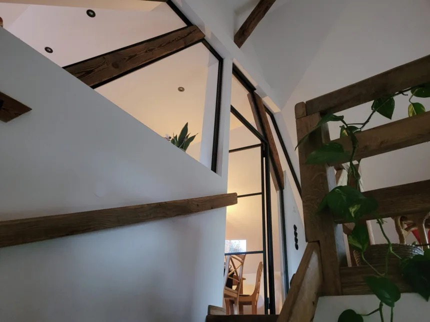Galerie mit Geländer aus altem Holz und Stahl-Glas-Wand